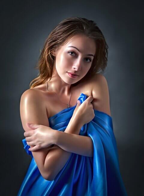 woman freshly showered and wrapped in a blue towel