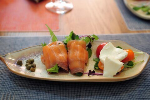 Photo of a plate of food including salmon and fresh cheese.