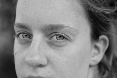 Black and white photo of a young woman's face showing eyes, nose and ear.