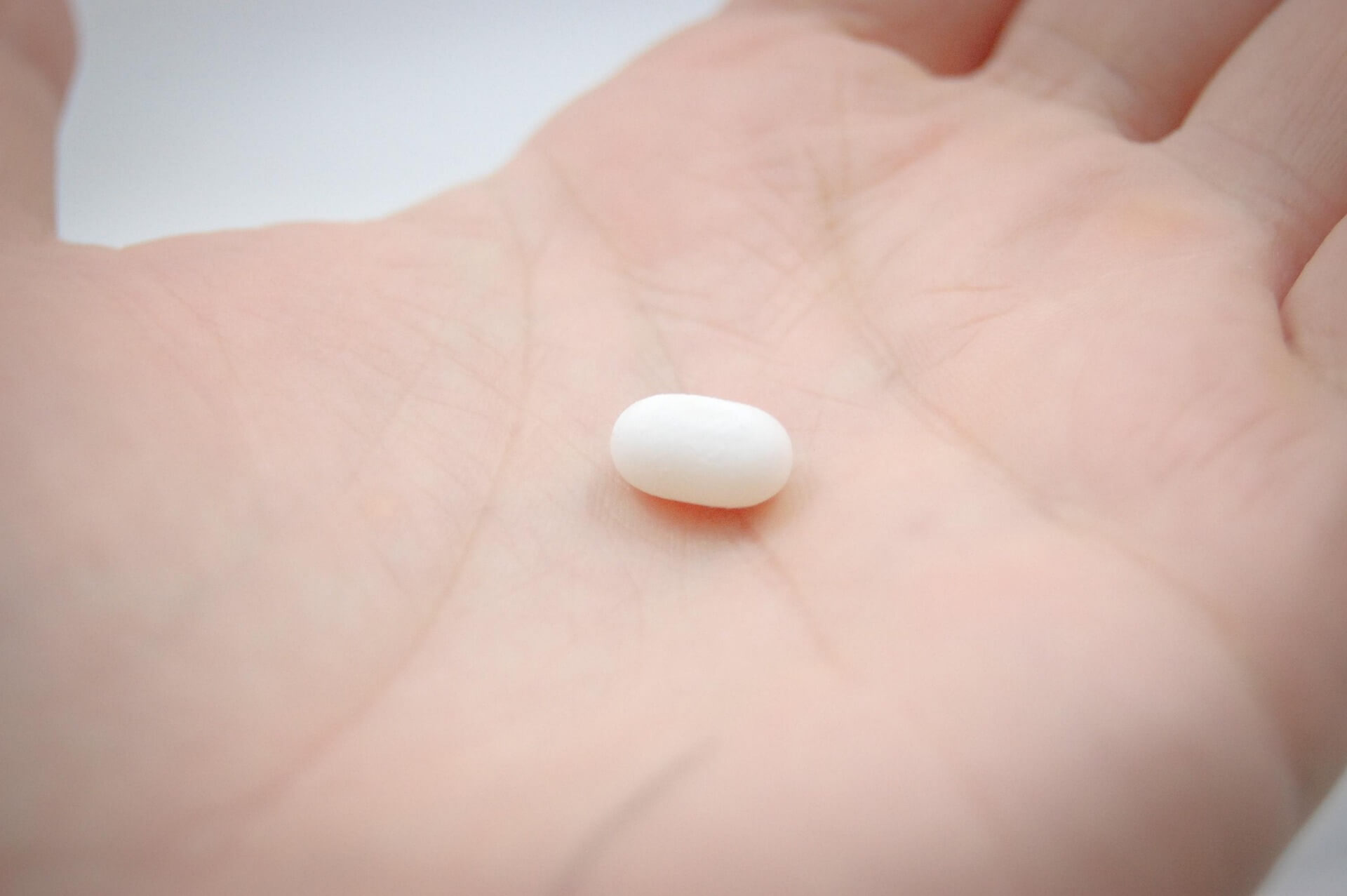 The morning after pill. Picture of a single white pill in a person's hand.