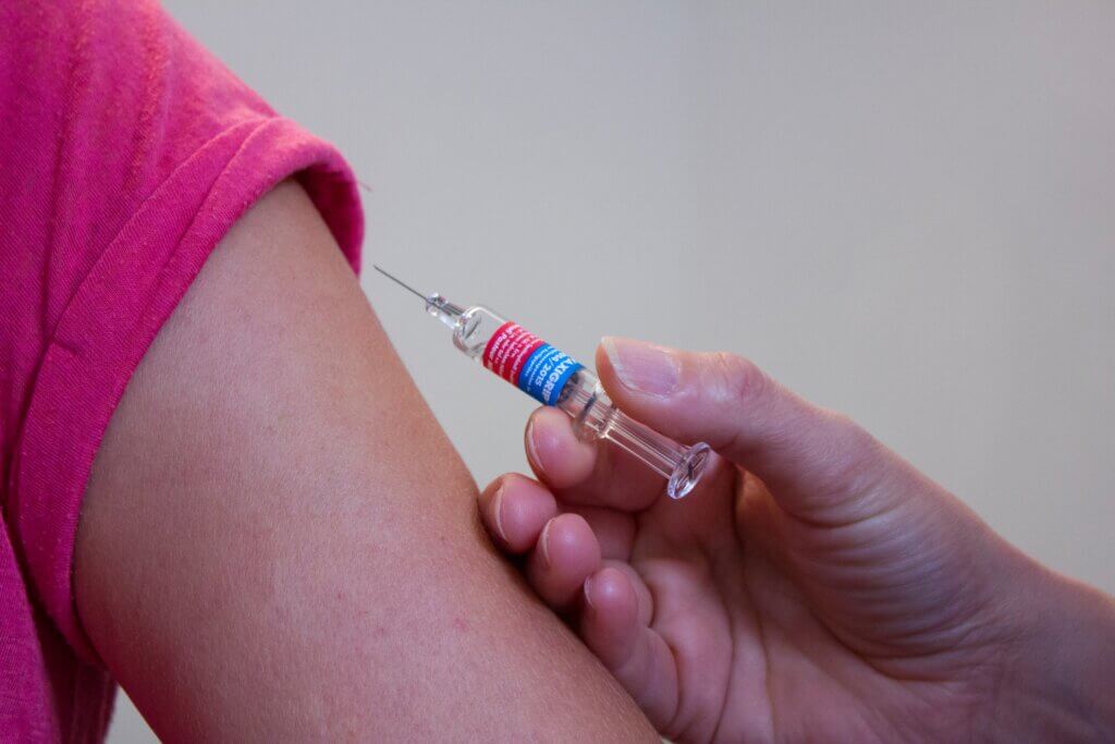 syringe with vaccination ready to be injected into a person's arm