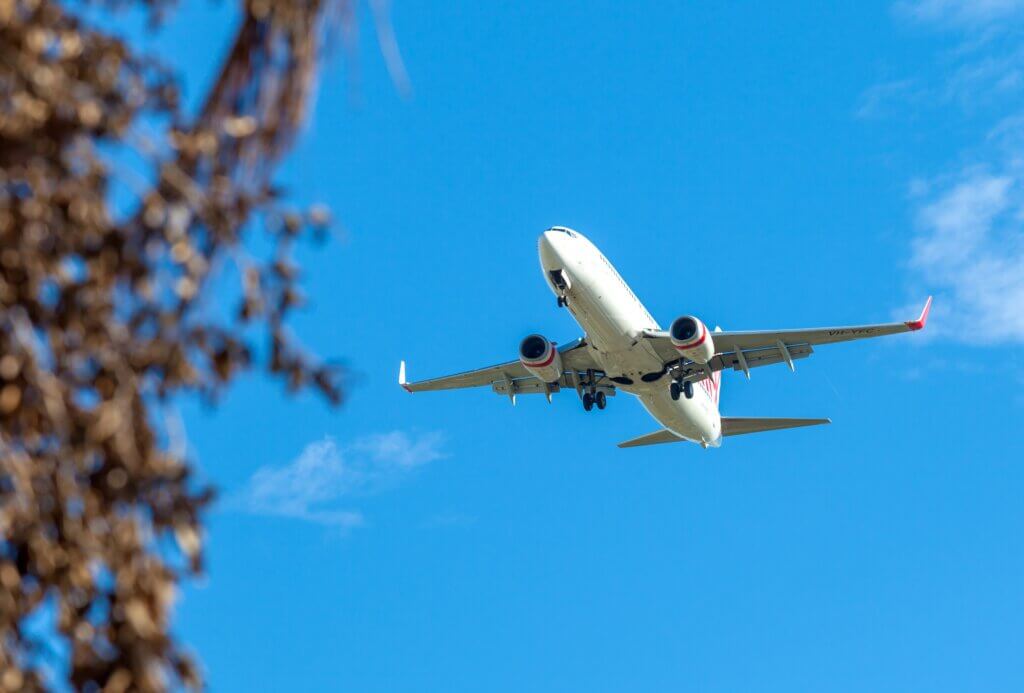 A photo of a low flying plane in a very blue sky