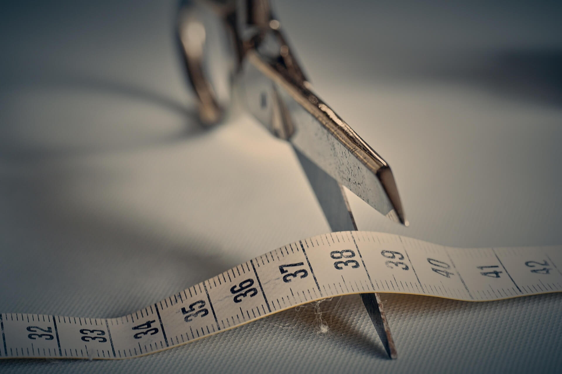 Wegovy tablets for weight loss - Photo of a a pair of scissors cutting into a tape measure